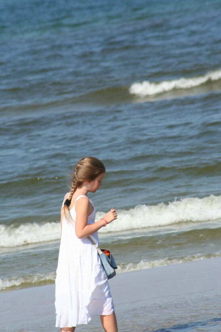 młoda dziewczyna idzie brzegiem plaży