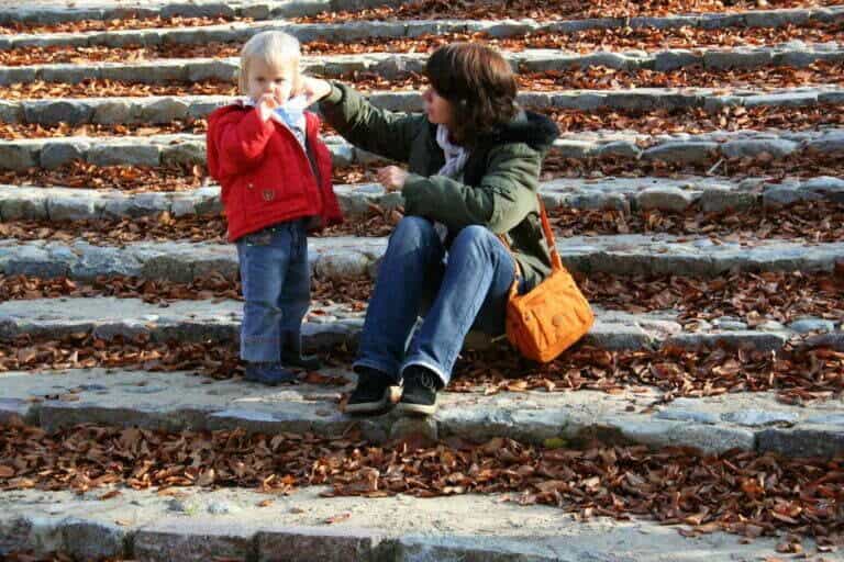 mama i córeczka na schodach, wokół jesienne liście