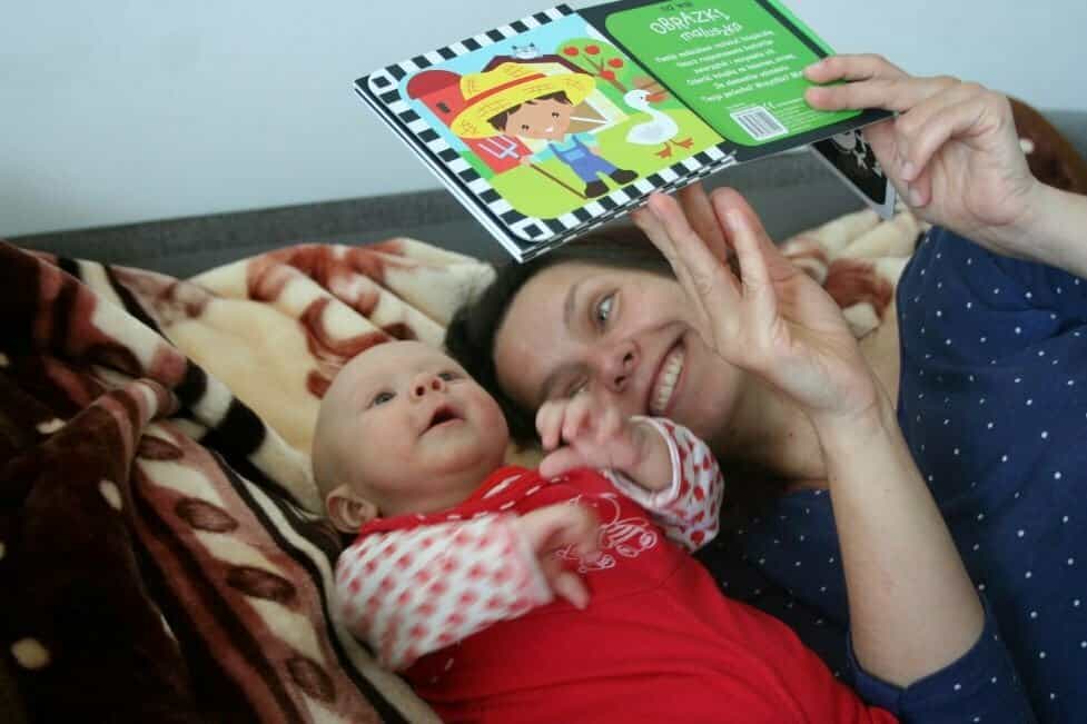 czytamy dzieciom - mama czyta malutkiemu dziecku, które jest skupione na książeczce