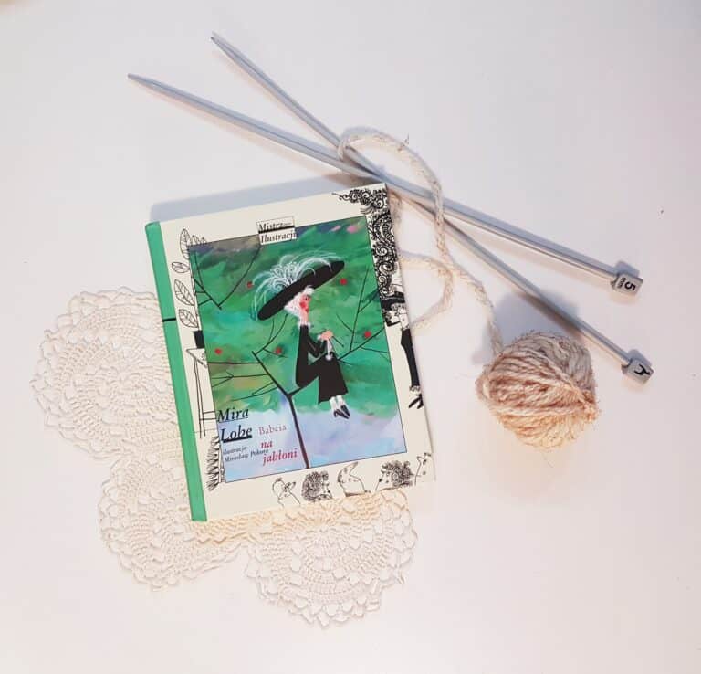 okładka książki "Babcia na jabłoni", obok ułożone są druty i kłębek nici