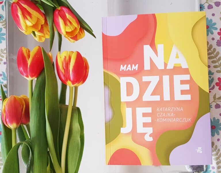 okładka książki "Mam nadzieję", obok leżąkolorystycznie dobrane tulipany