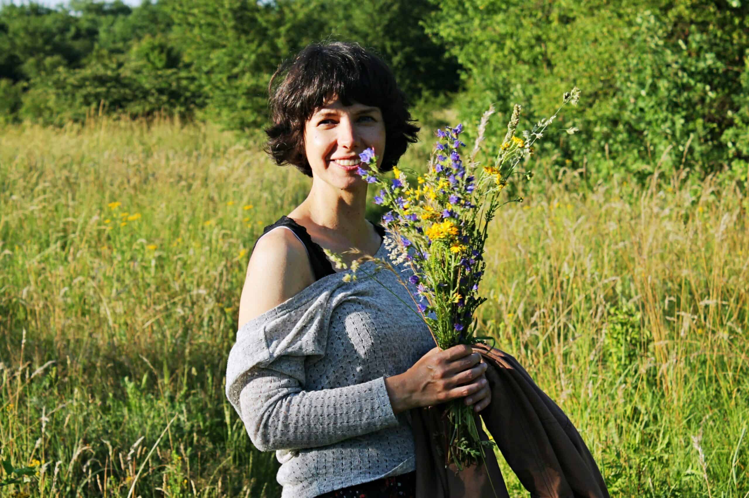 wakacje - autorka bloga na spacerze, na łące, z kwiatami w dłoni