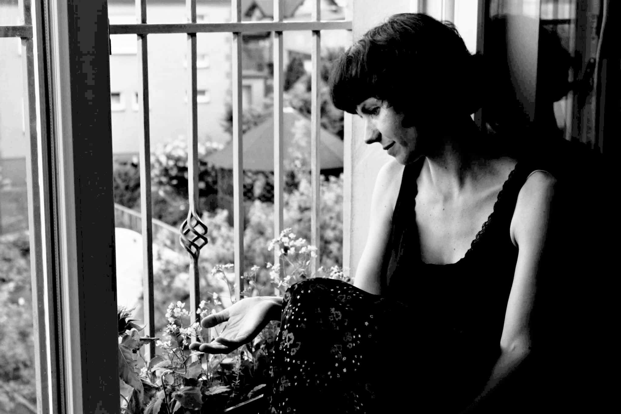 Ola, siedzi w oknie, zdjęcie czarno - białe, melancholijne, bo tematem jest czas