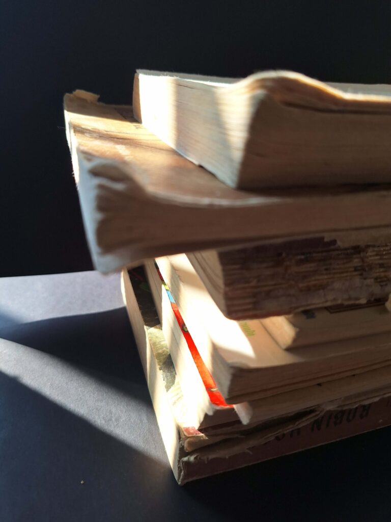 książki ułożone w stosik, prześwietlone słońcem